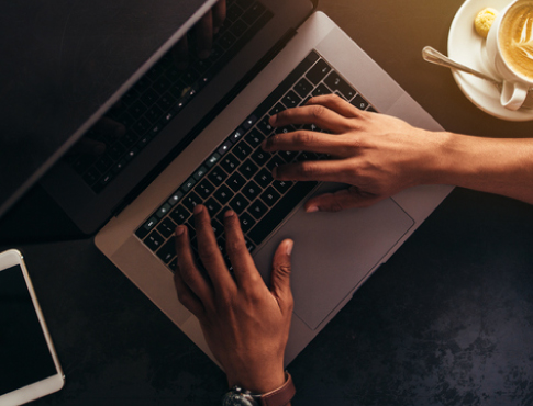 Hands typing on a laptop keyboard