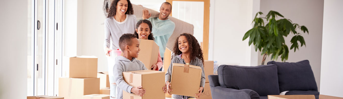A young family is moving boxes into their new home.