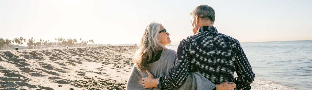 A mature couple walking on a beach