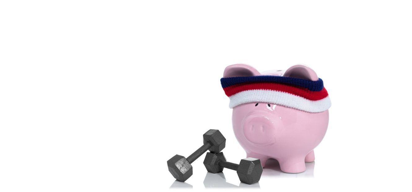 A picture of a piggy bank wearing a sweatband with two lifting weights lying in front 